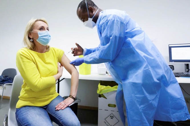 Doctor injecting a vaccine into the muscle of a lady