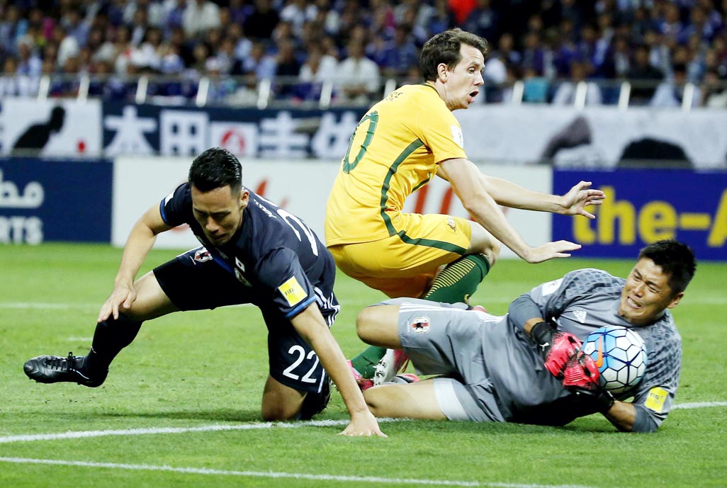Australia's Robbie Kruse (center) collides with Japan's goalkeeper Eiji Kawashima and Japan's Maya Yoshida (left) during their World Cup Group B qualifying soccer match in Saitama, Japan on Thursday.