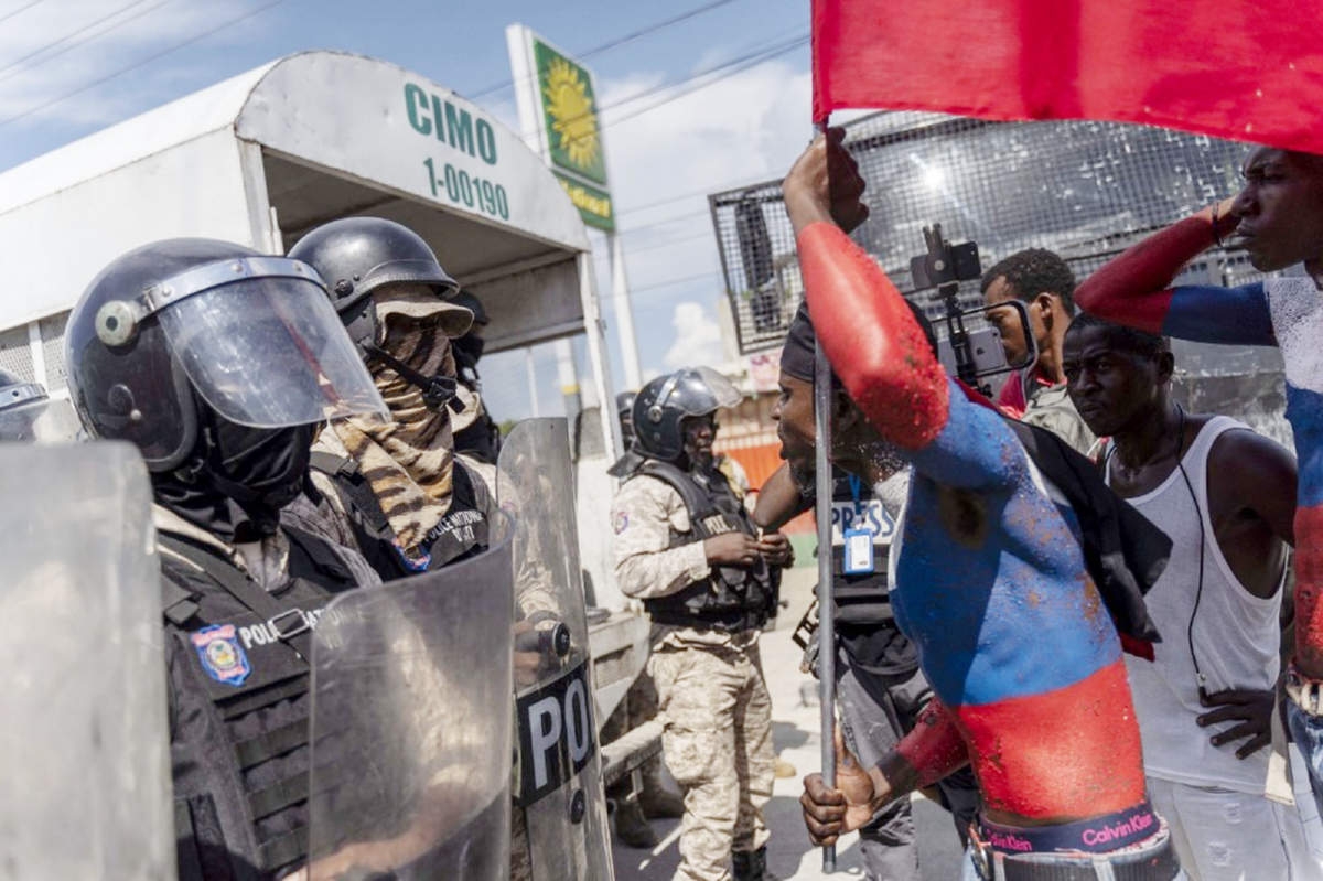 A protester taunts police officers during Jean-Jacques Dessalines Day in Port-au-Prince, Haiti on Monday. Agency photo