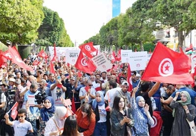 File photo: Supporters of the Tunisian Destouri party wave national flags and raise placards during a demonstration against President Kais Saied in the capital Tunis.
