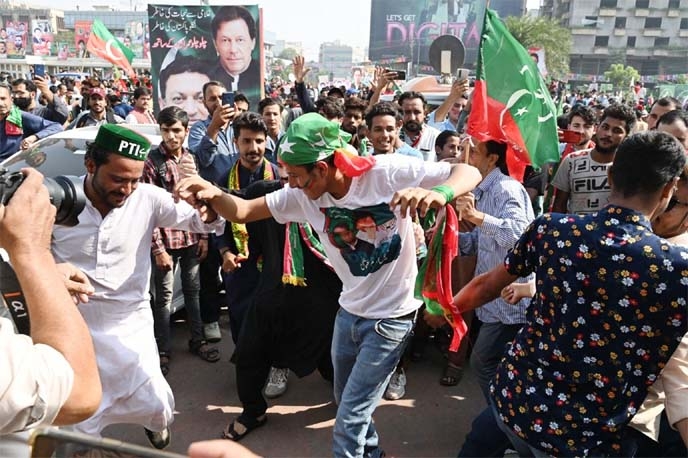 Activists and supporters of opposition party Pakistan Tehreek-e-Insaf (PTI) dance before the start of an anti-government long march towards Islamabad to demand early elections, in Lahore on Friday.