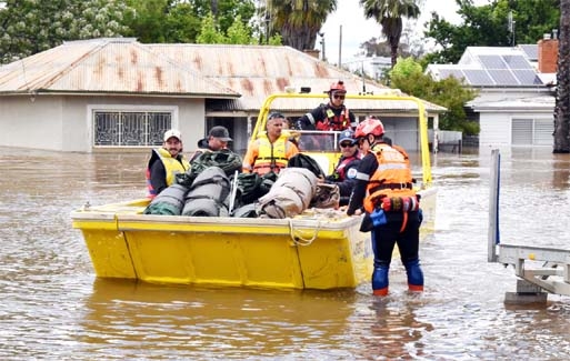 State Emergency Service personnel navigate floodwaters with residents and supplies aboard a watercraft at the town of Forbes on Wednesday.