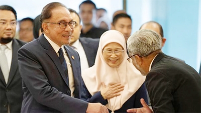 Malaysia's Prime Minister Anwar Ibrahim and his wife Wan Azizah Ismail are greeted by parliament staff as they arrive at Parliament House in Kuala Lumpur, Malaysia on Monday.