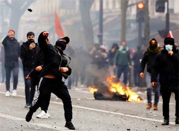 A person throws a projectile, as members of the Kurdish community attend a demonstration, following a shooting, in Paris, France on Saturday.