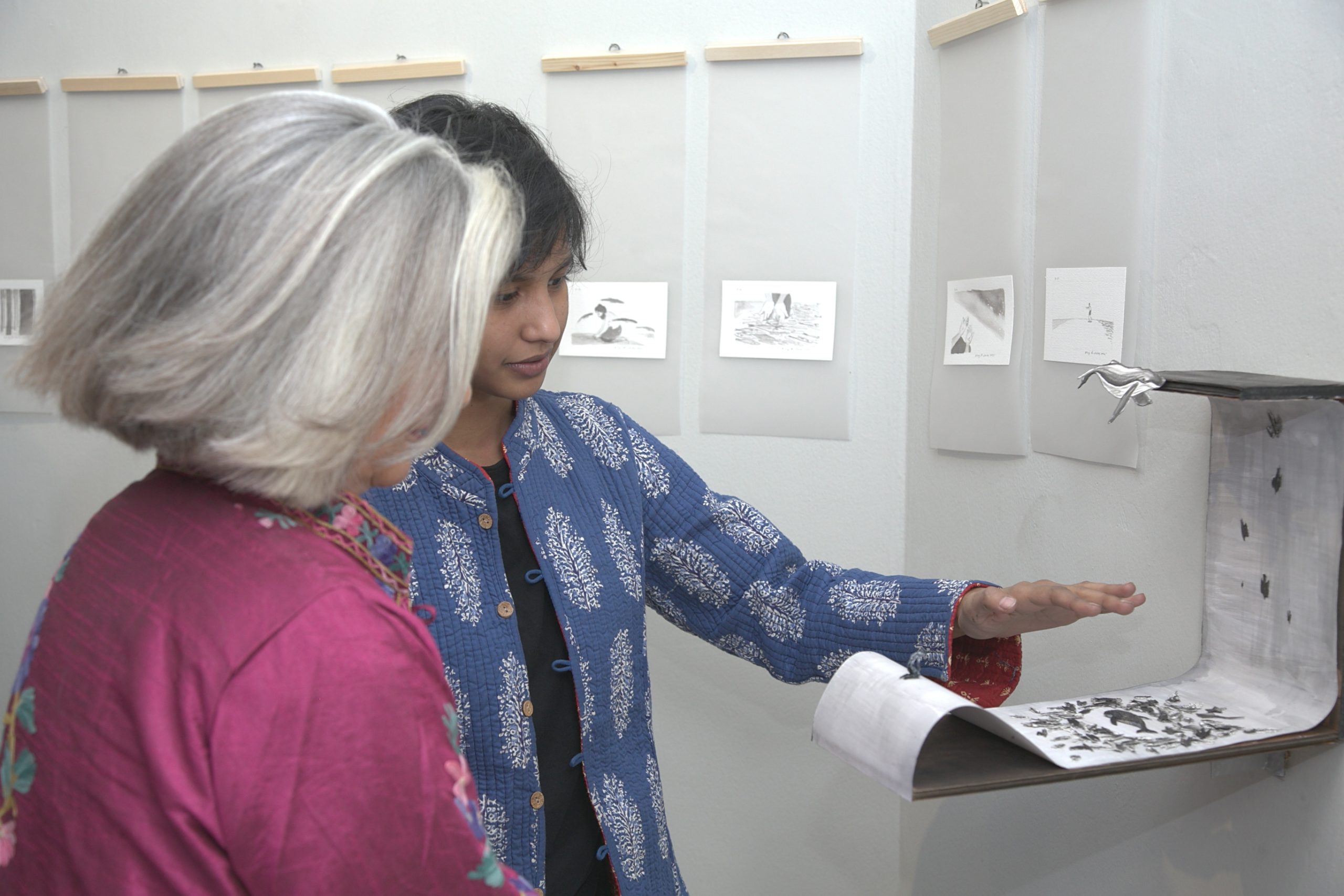 Afroza Hossain Sara (right) showing her art works to a visitor at the La Galerie of the Alliance Francaise de Dhaka. -NN Photo