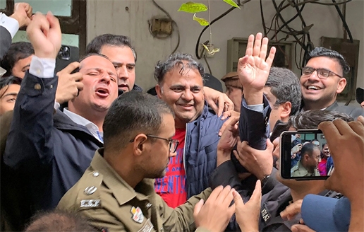 Police officials escort the Pakistan's former information minister Fawad Chaudhry to present him before a court in Lahore on Wednesday.