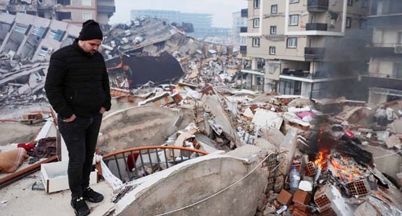 A man standing amid rubble looks at the damage following an earthquake in Hatay, Turkey on Tuesday. Agency photo