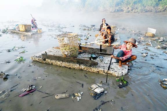 This photo shows waste collectors paddling polystyrene boats as they look for plastic and glass to recycle in Pazundaung Creek in Yangon. Agency photo
