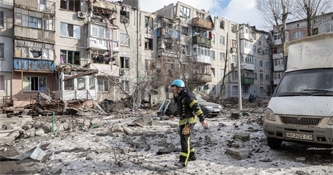 A firefighter walks at a car park near an apartment block that was heavily damaged by a missile strike, amid Russia's attack on Ukraine, in Pokrovsk, Donetsk region, Ukraine, February 15, 2023.