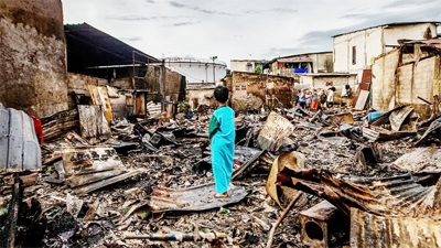 A boy stands in the remains of a burnt house in a residential area in Plumpang, north Jakarta on Saturday after a fire at a nearby state-run fuel storage depot run by energy firm Pertamina.