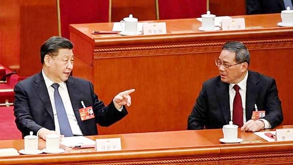China's President Xi Jinping (L) speaks with newly-elected Premier Li Qiang (R) during the fourth plenary session of the National People's Congress (NPC) at the Great Hall of the People in Beijing on Saturday. Agency photo