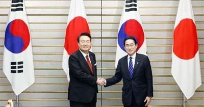 South Korea's President Yoon Suk Yeol, left, shakes hands with Japan's PM Fumio Kishida in Tokyo on Thursday.