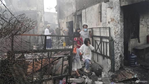 File photo: Residents walk though the rubble at a neighbourhood affected by a fuel depot fire in Jakarta, Indonesia, Saturday, Mar 4, 2023.