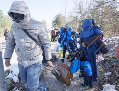 Asylum seekers cross the border at Roxham Road from New York into Canada on Friday in Champlain, N.Y.
